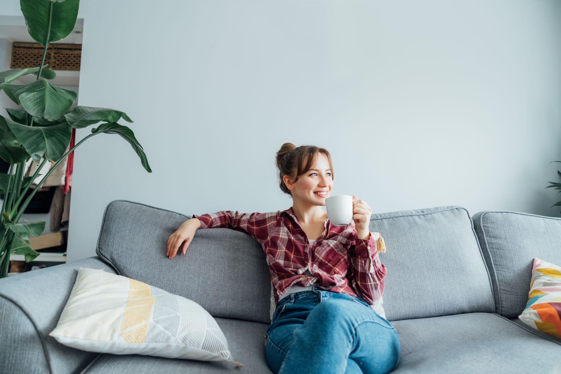 Frau lächelt entspannt auf dem Sofa