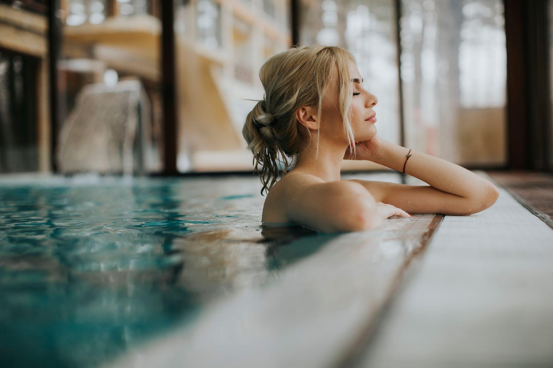 Frau entspannt im Spa-Bereich eines Hotels in der Fraenkischen Schweiz mit Blick auf den Innenpool
